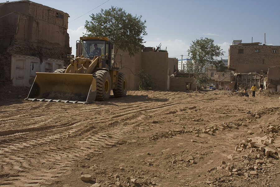 Bulldozer die een terrein effent in de oude stad van Kashgar